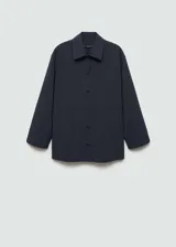 Camisa azul marino a rayas diplomáticas, de corte recto, con cuello camisero, cierre frontal con botones y dos bolsillos de parche en la parte delantera.