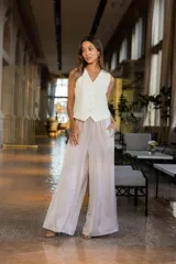 Pantalón amplio color beige con tejido fluido y diseño elegante.