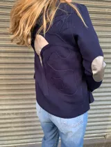 Cardigan azul marino tejido en algodón con detalles de cintas tejidas y cuero.