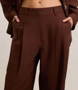 Pantalón wide leg de tiro alto color marrón chocolate, confeccionado en tejido de lino y viscosa. Incluye cinturón de cuero sintético con hebilla metálica.