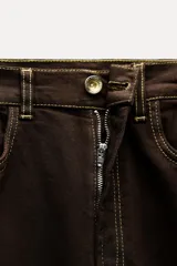 Pantalón de jean marrón oscuro, de tiro alto, corte slim fit y bootcut, con cinco bolsillos y pespuntes a contraste.