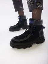 Botas de caña media color marrón de cuero gamuzado, con suela track y cordones rojos.