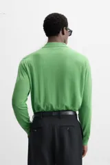 Polo verde de punto ligero tejido en hilatura de lana, corte regular fit, cuello solapa con cierre frontal de botonadura, manga larga y acabados en rib.