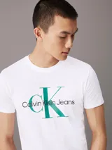 Remera blanca de corte slim, cuello redondo y mangas cortas. Estampado frontal con el logo de Calvin Klein Jeans en verde y negro.