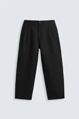 Pantalón negro relaxed fit confeccionado en tejido con algodón, lino y lyocell. Cintura con detalle de pliegues frontales dobles, bolsillos delanteros y traseros. Cierre frontal con cremallera y botón.