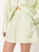 Short amarillo de tiro alto con pinzas delanteras y cierre invisible lateral.