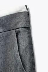 Pantalón ancho gris con textura de espiga, tiro alto, doble cintura elástica ajustable con cordón, pinzas frontales, bolsillos delanteros y falso bolsillo de vivo en la espalda.