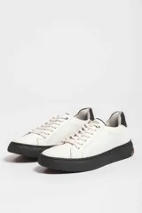 Zapatillas urbanas blancas con detalle azul en el talón y suela de goma.