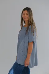 Blusa celeste de corte holgado con mangas cortas y detalle de bordado calado en el frente.