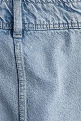 Minifalda de jean celeste, de corte evasé, con cintura alta y cierre lateral oculto.