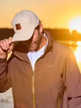 Gorra de gabardina color gris con visera curva y aplique de cuero con logo en el frente. Ajuste trasero con hebilla metálica.