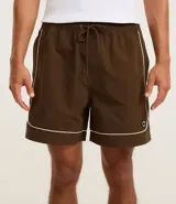 Bermuda deportiva masculina color marrón, con cintura elástica y cordón ajustable. Presenta piping contrastante en blanco a lo largo de los bordes y bolsillos funcionales. Confeccionada en poliamida de secado rápido.