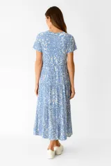 Vestido midi de viscosa con estampado de hojas en tonos beige y marrón, corte ancho, cuello en V y mangas cortas con volados.
