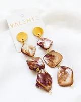 Pendientes largos con detalle en piedra acrílica en tonos marrones y dorados.