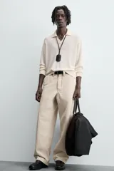 Sweater color crema de punto, con cuello polo y mangas largas. Tejido en hilatura de cáñamo con acabados en rib.