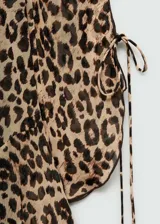 Vestido corto con estampado animal print, cuello redondo y mangas largas con lazos en los puños.