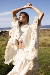 Ruana marrón tejida en lana merino con detalles de lino y flecos.