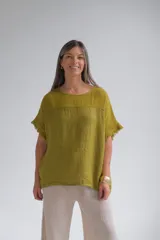 Remera color verde pistacho de lino italiano, con escote a la base, corte amplio y mangas cortas con detalle de flecos.