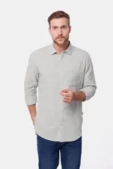 Camisa de lino color beige, de manga larga, con cuello clásico y bolsillo en el pecho.