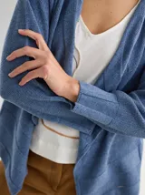 Saco abierto color blanco hueso, tejido de punto con textura combinada y mangas largas. Diseño liviano y de caída suave.