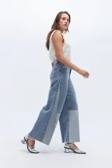 Pantalón de jean wide leg de diseño bicolor en denim de algodón. Presenta una silueta holgada y de pierna ancha con contraste entre los tonos de gris claro y oscuro. Tiene pretina alta.