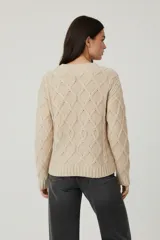 Sweater de chenille color blanco, con punto trenzado, diseño holgado y cuello a la base.