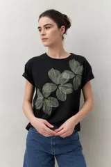 Remera blanca de manga corta con estampado floral en tonos dorados en el frente.