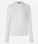 Suéter blanco de punto con cuello alto y frufrú en cuello y puños.
