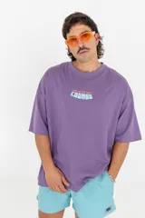 Remera violeta de corte holgado con estampa frontal con la frase "Lost in the vast cosmos".
