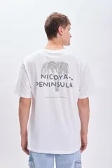 Remera blanca de manga corta con corte oversize y estampa en la espalda con palmeras y texto "Nicoya Peninsula".