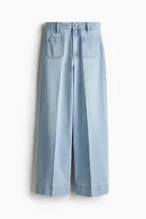 Pantalón de jean celeste de pierna ancha, tiro alto, con bolsillos de parche delanteros y traseros.