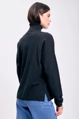 Polera negra de punto de rib con cuello alto y mangas largas.