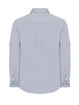 Camisa celeste de manga larga con cuello camisero, cierre con botones de madera y bolsillo en el pecho.