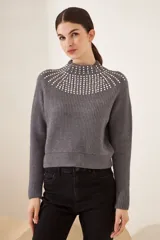 Sweater gris con diseño de strass en el cuello y corte ajustado, ideal para combinar con jeans.