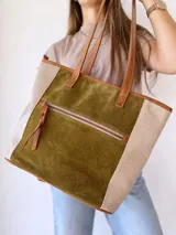 Bolso tipo tote de cuero color verde oliva con laterales de cuero texturizado color beige y manijas de cuero color marrón.