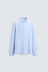 Camisa celeste a rayas verticales blancas, de corte recto, con cuello italiano abierto, mangas largas con puños abotonados y cierre frontal con botones.