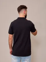 Remera polo color beige, de piqué de algodón, con cuello clásico y tapeta de dos botones.