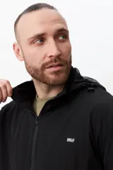 Campera deportiva negra con capucha y cierre frontal.