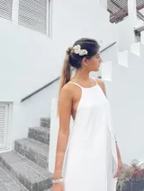 Vestido corto blanco con escote halter y espalda descubierta con tiras ajustables.