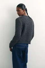 Cárdigan gris oscuro de tejido de punto con textura, cuello redondo, cierre frontal con botones dorados y terminaciones acanaladas en cuello, puños y bajo.
