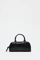 Bolso mini tipo bowling color negro, con doble compartimento con cierre de cremallera, asa de mano y asa bandolera extraíble.