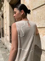 Vestido midi color beige, de corte recto y sin mangas, con estampado de líneas blancas.