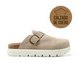 Zueco de cuero color beige con hebilla ajustable, plataforma de corcho y suela blanca con diseño dentado.