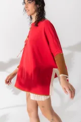 Sweater rojo de algodón con mangas largas color marrón acanalado y cuello redondo.