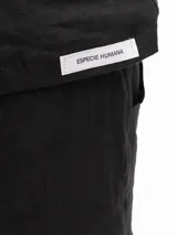 Remera negra de lino con mangas cortas y corte holgado. Tiene botones en la espalda.