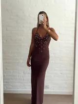 Vestido largo marrón con escote halter y espalda descubierta, con apliques de strass plateados en el corpiño.