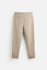 Pantalón negro de corte cropped, con cintura elástica ajustable con cordón, bolsillos laterales y traseros de vivo. El bajo tiene terminación con vuelta.