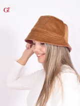 Sombrero tipo bucket reversible, de color albaricoque (apricot) o rosa viejo en un lado, y marrón claro en el reverso. Presenta costuras horizontales en el ala.