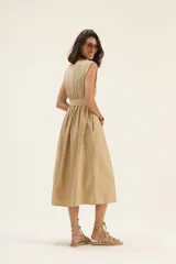 Vestido midi color beige, sin mangas, con lazo en la cintura y bolsillos laterales.