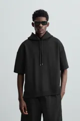 Sudadera negra de algodón con capucha ajustable y mangas cortas.